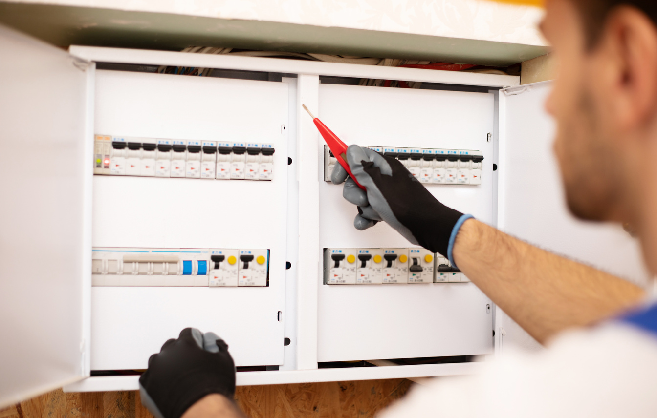 Electrician Checking an Electrical Panel with Fuses